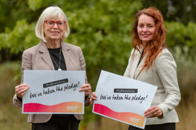 Cllr Kendrick and Hobbs holding Poverty Pledge signs
